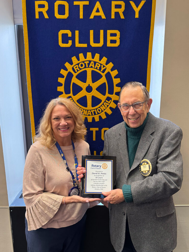 President Linda Osterfeld presents Dr. David H. Ponitz with a plaque recognizing 50 years of dedicated service to the Club and the community.