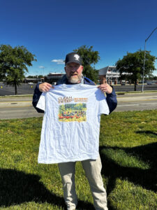 A volunteer holds a Great Miami Riverway Clean Sweet t-shirt.