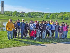 Rotary volunteers pose together in front of the Carillon Tower along the Great Miami River.
